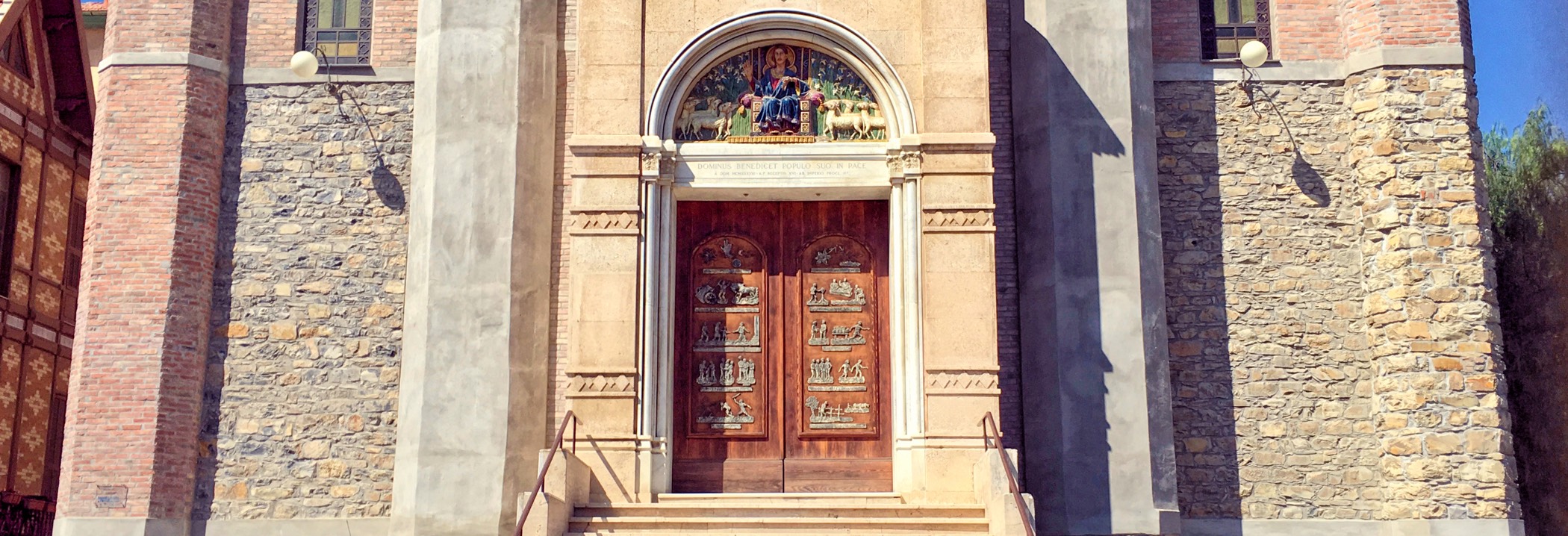 Chiesa Parrocchiale di Cristo Re a Imperia Porto Maurizio visione frontale con caratteristica porta intarsiataa mano.
